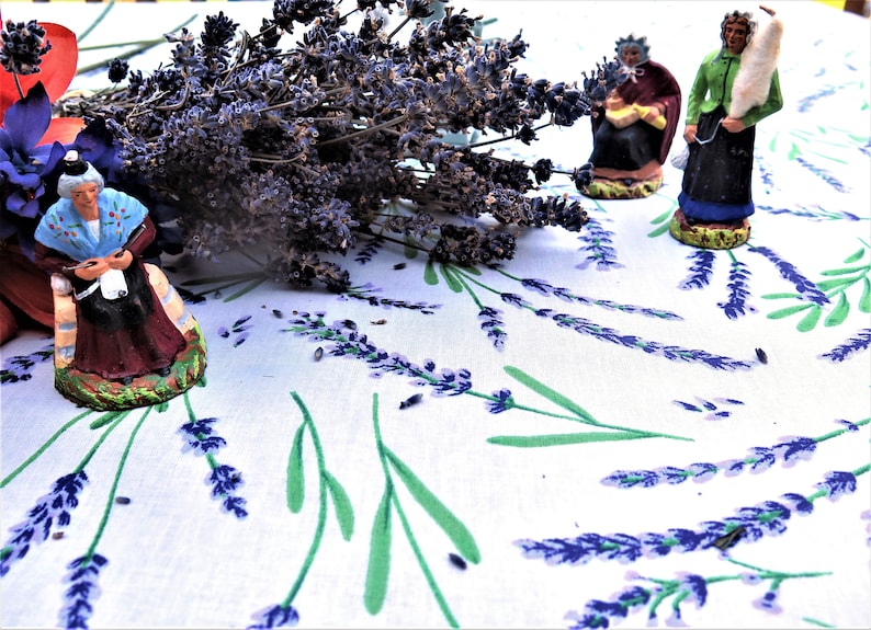 The cotton fabric of this rectangular tablecloth is coated with an acrylic film to make it stain and water resistant. So easy care! No need to wash it in the machine! 
Many sizes available. Purple Lavender with green leaves in white.