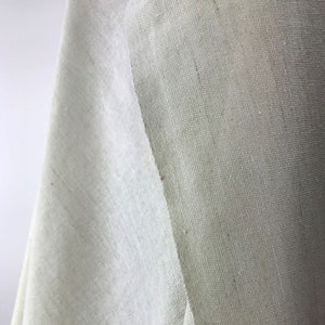 Könnte beinhalten: Nahaufnahme eines weißen, durchsichtigen Stoffes mit feiner Maschenstruktur. Der Stoff ist in der Mitte gefaltet und zeigt beide Seiten.