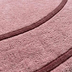 May include: A circular rug with a textured, light pink pile surface featuring a darker, deep pink circular border line. The text TheHandRugsCo is printed in the bottom right corner of the rug in a simple, light-colored font.