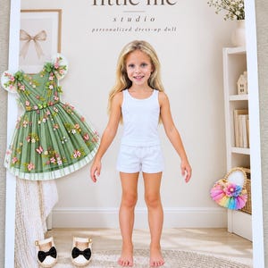 May include: A personalized dress-up doll set featuring a child figure in a white tank top and shorts, a sage green tulle dress with floral and butterfly embroidery, a pair of white shoes with black bows, and a rainbow-colored basket.