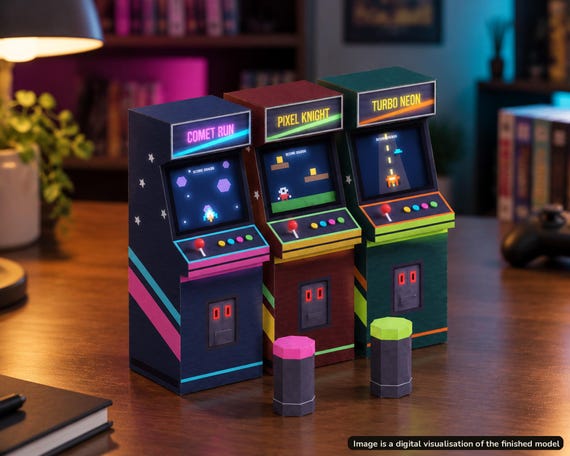 Visualisation of three finished retro arcade cabinet paper models with neon side art, on a desk indoors