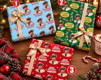 May include: Three rectangular gift boxes wrapped in patterned paper with gold ribbons. Box one is light blue with text "my Christmas presents." Box two is green with text "MERRY CHRISTMAS TO ALL YOU SUMBITCHES." Box three is red with the same text.