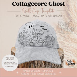 May include: A light gray five-panel trucker hat featuring a black line art graphic of a ghost, mushrooms, flowers, bats, and a crescent moon. The text Cottagecore Ghost Ball Cap Template for 5 Panel Trucker Hats or Similar is visible.