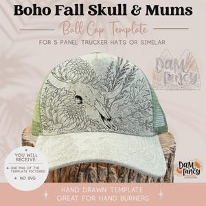 Peut inclure: Un modèle de casquette trucker de couleur claire avec une illustration au trait noir représentant un crâne entouré de chrysanthèmes et de feuillage. Le texte indique Boho Fall Skull & Mums Ball Cap Template for 5 Panel Trucker Hats.