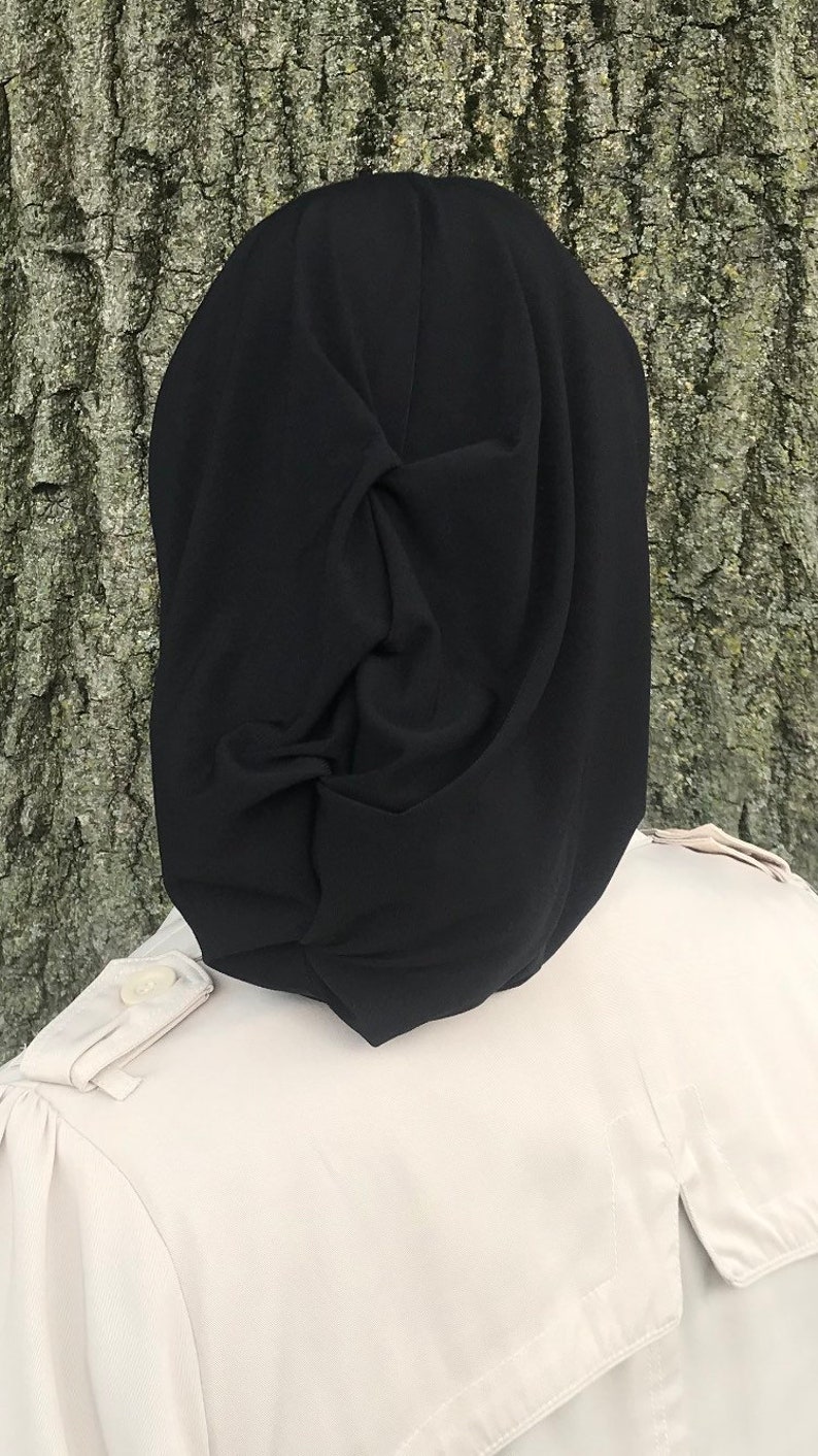 K&ouml;nnte beinhalten: Ein schwarzes Kopftuch mit einem Knotendesign. Das Tuch ist aus einem weichen, glatten Stoff.