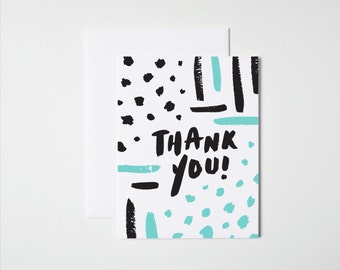 May include: A white thank you card with black and blue abstract shapes and the text "THANK YOU!" in black.
