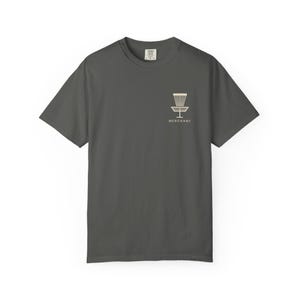 Puede incluir: Una camiseta gris carbón de manga corta con un pequeño gráfico de color claro en el pecho izquierdo. El gráfico muestra un icono de cesta de disc golf sobre el texto "MERCHANT" en una fuente sans-serif clara. Cuello redondo.