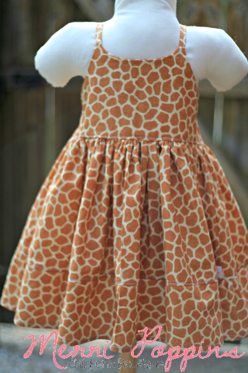 K&ouml;nnte beinhalten: Ein &auml;rmelloses Kleid mit Giraffenmuster. Das Kleid hat einen gerafften Rock und ist aus einem weichen, leichten Stoff gefertigt. Das Kleid ist perfekt f&uuml;r einen Sommertag.