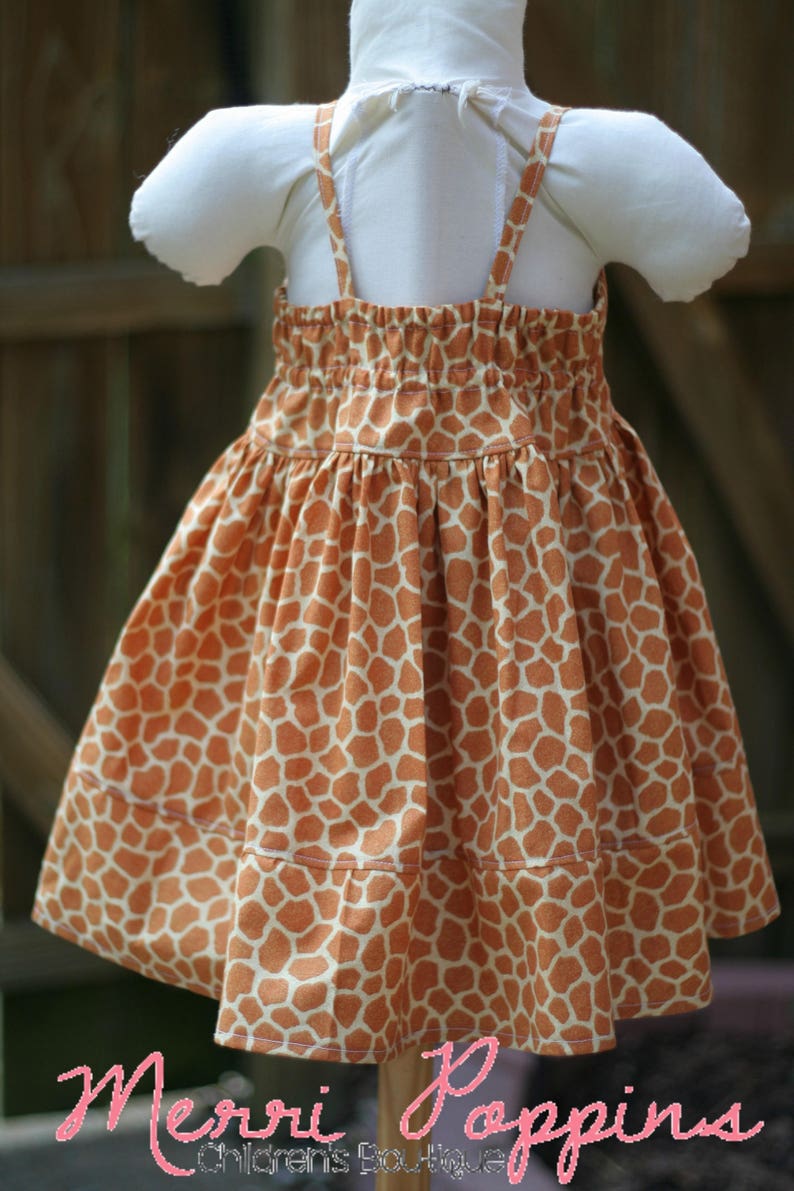 K&ouml;nnte beinhalten: Ein &auml;rmelloses Kleid mit Giraffenmuster. Das Kleid hat eine geraffte Taille und einen Stufenrock. Das Kleid ist aus einem weichen, leichten Stoff.