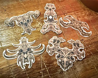 May include: Five die-cut stickers featuring intricate, beige and brown illustrations of fantasy bone-like structures and skeletal creatures. Each sticker displays detailed textures, sharp edges, and organic, horn-like protrusions in a variety of shapes.