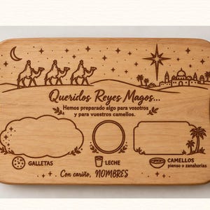 Puede incluir: Una tabla de servir rectangular de madera con asas, grabada con láser con una escena de los Reyes Magos, estrellas y texto en español. Incluye áreas designadas para galletas, leche y comida para camellos, con la frase Queridos Reyes Magos.