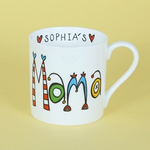 May include: White ceramic mug with a colourful "Mama" design and the text "Sophia's" in black lettering on the top rim.