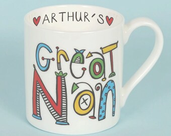 Puede incluir: Taza de cerámica blanca con un diseño colorido que dice "Great Nan" y "Arthur's" en corazones rojos.