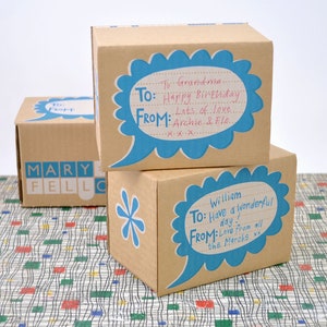 May include: Two brown cardboard gift boxes with blue speech bubbles. The top box has the text "To: Grandma. Happy Birthday. From: Lots of love. Archie & Flo." The bottom box has the text "To: William. Have a wonderful day! From: Love from all the Marahs xx."