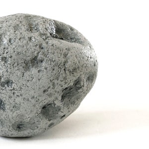 May include: A large, gray, irregularly shaped rock with a rough, textured surface.
