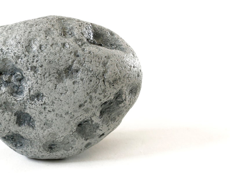 May include: A large, gray, irregularly shaped rock with a rough, textured surface.