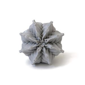 May include: A light gray, spherical object with a complex, repeating geometric pattern of pointed, star-like protrusions. The surface has a matte, textured finish, and the structure radiates outward from a central point in a symmetrical design.