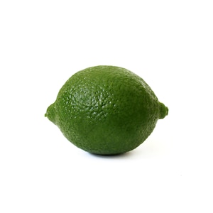 Peut inclure: Un citron vert unique, de couleur verte et à la texture bosselée, isolé sur un fond blanc.