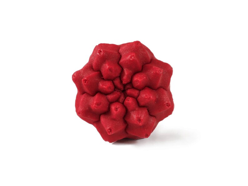 May include: A bright red, multi-faceted geometric object with a complex, repeating star-like pattern. The surface features a textured, granular finish with numerous pointed protrusions radiating from the centre in a symmetrical, radial arrangement.