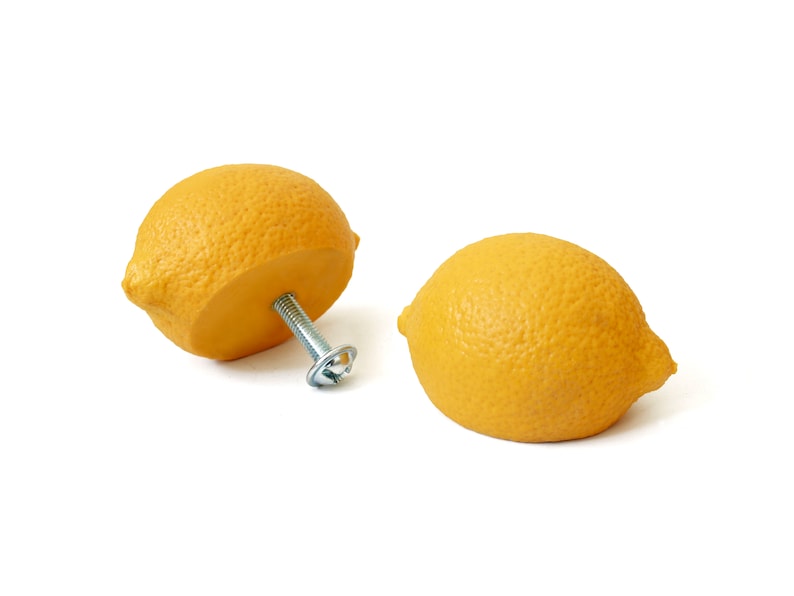 Peut inclure: Deux poign&eacute;es de tiroir en forme de citron jaune avec une vis argent&eacute;e au centre de l'une.