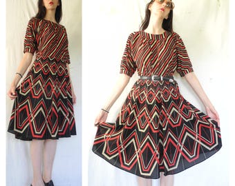 Vestido midi de manga corta con estampado geométrico y rayas dobles en rojo, negro y beige de estilo hippie de los años 70.