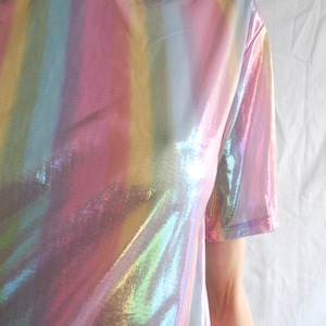May include: An iridescent rainbow striped t-shirt made of a sheer, shiny fabric.