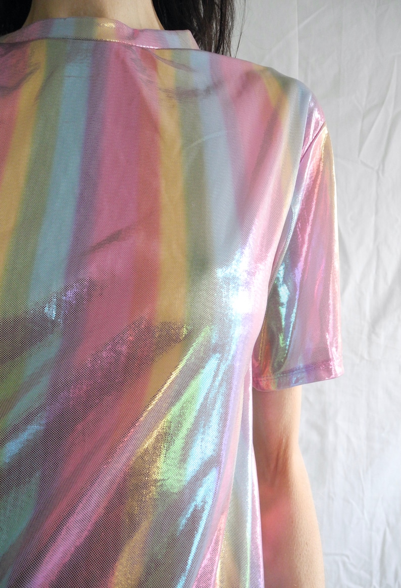 May include: An iridescent rainbow striped t-shirt made of a sheer, shiny fabric.