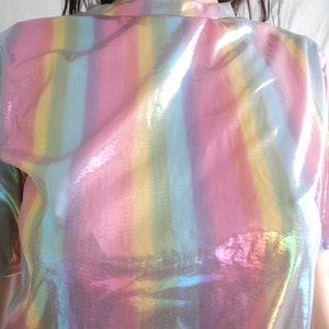 May include: An iridescent rainbow striped shirt with a high neck and short sleeves.