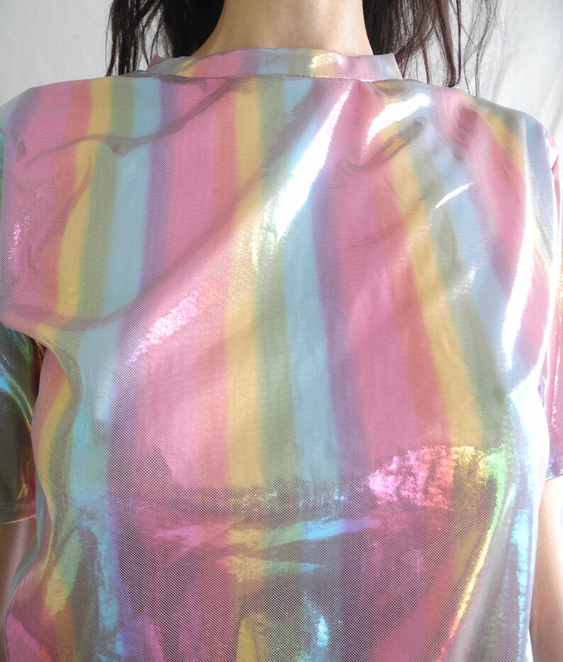 May include: An iridescent rainbow striped shirt with a high neck and short sleeves.