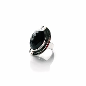 Absolutely stunning black onyx cocktail ring in sterling silver setting. Multi Faceted Oval Cut Onyx gemstone.