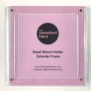 May include: A clear acrylic frame with a pink and white striped background. The frame has a black circle with the text "the sweetest tiers" and the text "Sweet Stencil Holder Extender Frame" below it. The frame also has the text "www.thesweetestiers.com Instagram @thesweetestiers" at the bottom.