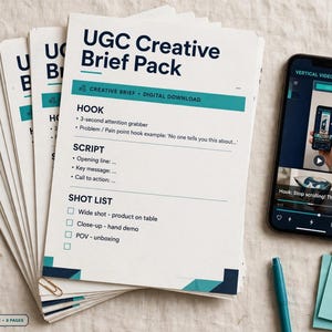 以下が含まれることがあります： UGC Creative Brief Packと書かれたティール色のアクセントがある白い書類の束。フック、スクリプト、ショットリストのセクションが含まれています。横にはビデオドラフトを表示したスマートフォンと、Ready to customizeと書かれた付箋が置かれています。