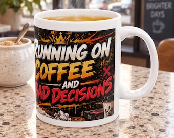 May include: A white ceramic mug featuring a graphic design with the text RUNNING ON COFFEE AND BAD DECISIONS in bold yellow and red lettering. The design includes a crown icon, paint splatter effects, and a small coffee cup illustration.