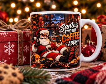 May include: A white ceramic mug featuring a colorful illustration of Santa Claus wearing headphones and sunglasses while gaming. The text reads Santa's Favorite Coffee Addict. Santa is sitting in a chair with a dog nearby, surrounded by gaming equipment and cookies.