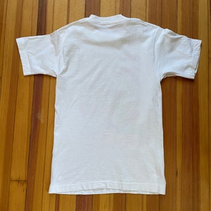 May include: A white short-sleeved t-shirt with a crew neck.