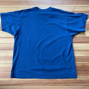 Puede incluir: Una camiseta lisa de color azul marino con mangas cortas.