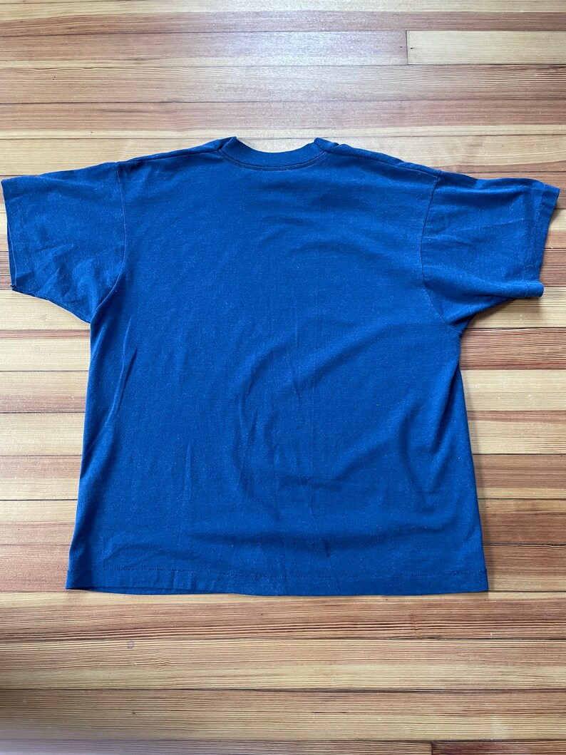 Puede incluir: Una camiseta lisa de color azul marino con mangas cortas.
