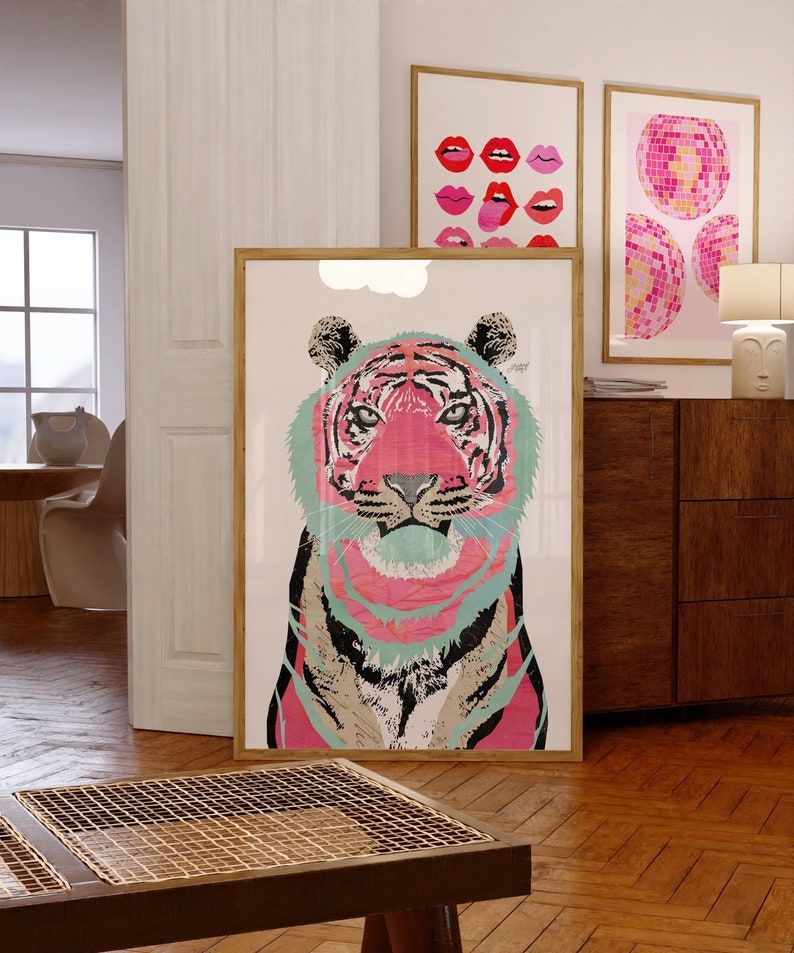 May include: A framed print of a colorful tiger with pink, blue, and black stripes. The tiger's eyes are black and the background is white.