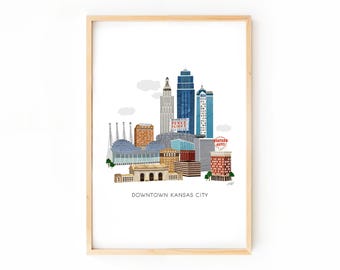 Könnte beinhalten: Ein gerahmter Kunstdruck mit einer farbenfrohen Illustration der Skyline von Kansas City. Das Kunstwerk zeigt verschiedene Gebäude in Blau-, Orange- und Brauntönen, mit dem Text "Downtown Kansas City" am unteren Rand.
