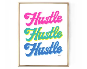 May include: A framed art print with the word "Hustle" in three stacked lines. Each word is in a different color: pink, teal, and blue, with a shadow effect. The frame is gold.