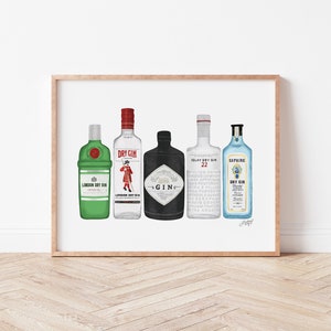 May include: A framed print featuring five different gin bottle illustrations. The bottles vary in color, including green, white, black, and blue, with labels that read "London Dry Gin" and "Sapphire Dry Gin". The artwork is displayed on a white background.