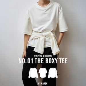 Op de afbeelding: Een off-white boxy t-shirt met korte mouwen en een gestrikt detail in de taille. De tekst luidt sewing pattern NO.01 THE BOXY TEE BY MAREN, vergezeld door drie zwart-witte lijntekeningen van verschillende t-shirtvarianten.