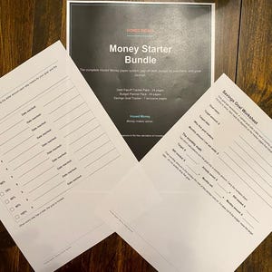 Op de afbeelding: Een Money Starter Bundle papiersysteem met een donkere omslag met witte tekst, een Savings Milestones blad met procentuele selectievakjes en een Savings Goal Worksheet met lege regels voor financiële planning.