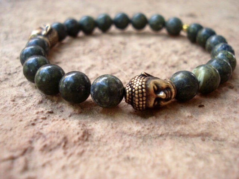 May include: A green stone beaded bracelet with a gold-toned Buddha head charm.