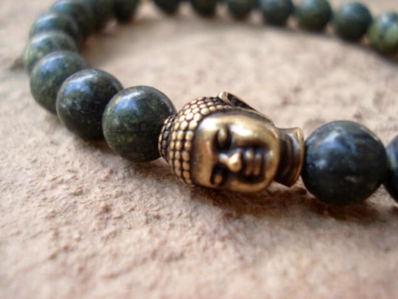 May include: A green stone beaded bracelet with a gold Buddha head charm.