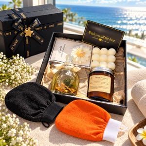 May include: A black gift box containing a glass fragrance bottle, a flower-shaped candle, a bubble candle, an amber jar candle, and a black card with the text Wish you all the best. Includes a black exfoliating mitt and an orange exfoliating mitt.