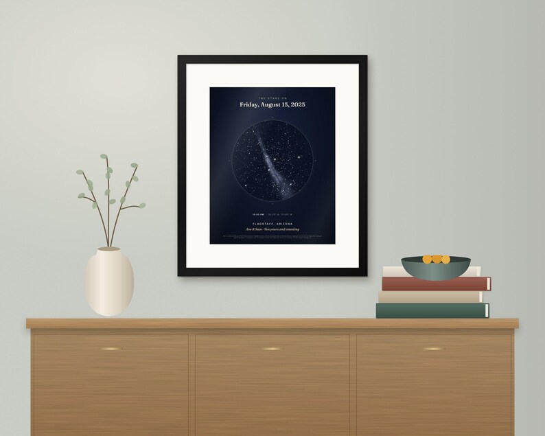 May include: A framed star map print featuring a dark blue night sky with a circular constellation graphic, the text "Friday, August 15, 2025", "Flagstaff, Arizona", and "Ana & Sam - Ten years and counting" in a black frame with a white mat.