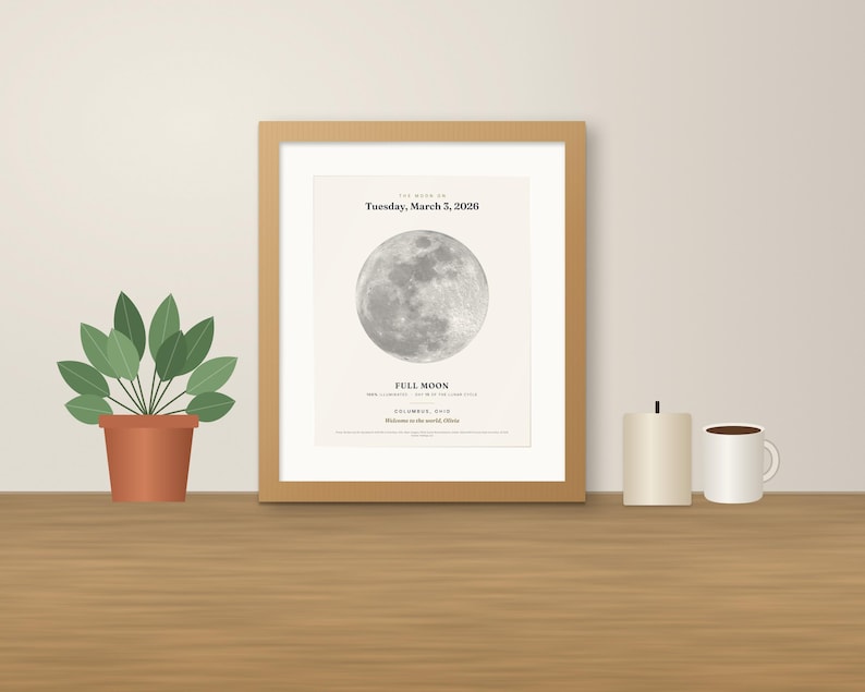 May include: A framed wall art print featuring a detailed greyscale image of a full moon. The text reads: The moon on Tuesday, March 3, 2026, Full Moon, Columbus, Ohio, Welcome to the world, Olivia. The print is housed in a light wood frame.