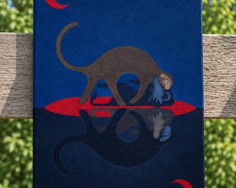 Peut inclure: Une peinture sur toile rectangulaire représentant un singe brun debout sur une forme ovale rouge sur un fond bleu foncé. Un croissant de lune rouge se trouve en haut à gauche et un autre en bas à droite. Le singe se reflète dans l'ovale rouge.