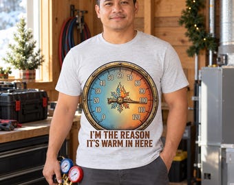 Pode incluir: Uma t-shirt cinzenta clara de manga curta com um gráfico circular grande de um termómetro com gradiente azul e laranja. O centro mostra um ícone de floco de neve e chama. Abaixo do medidor está o texto: I'M THE REASON IT'S WARM IN HERE.